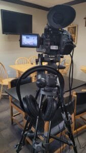 Camera mounted on tripod, powered on & with headset plugged in